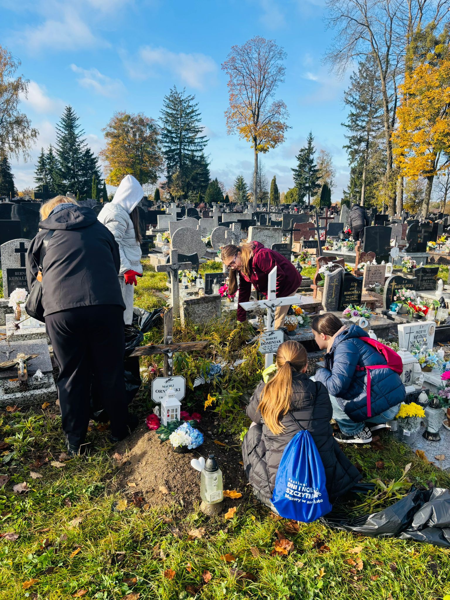 Wolontariusze sprzątają groby na cmentarzu komunalnym w Szczytnie