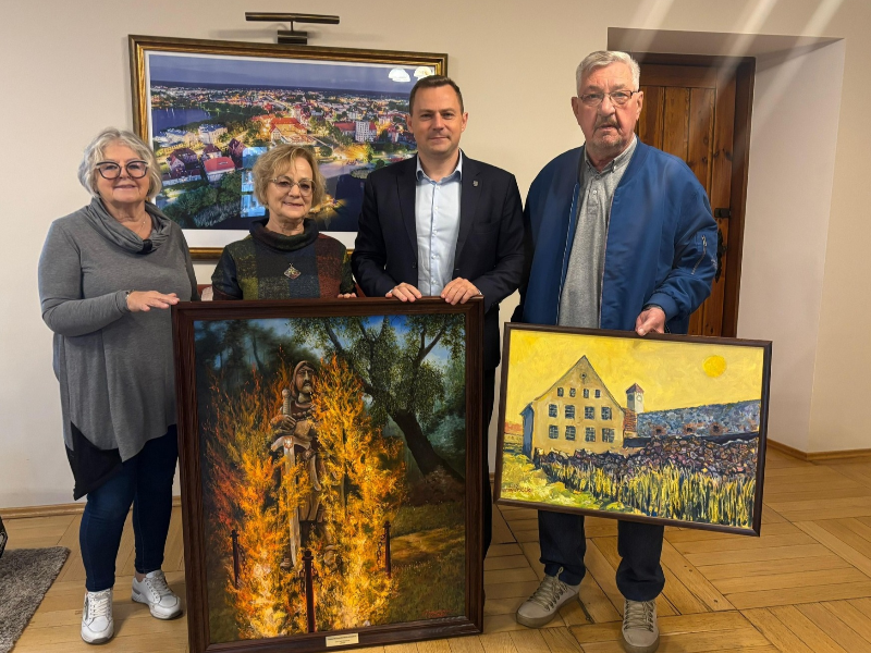 4 osoby z 2 obrazami w dłoni