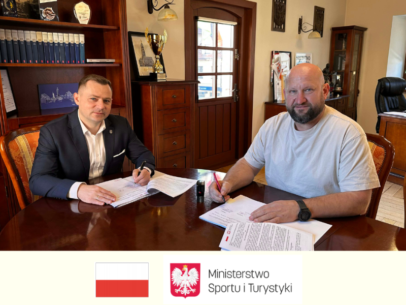 dwie osoby, przy stole podpisywanie umowy